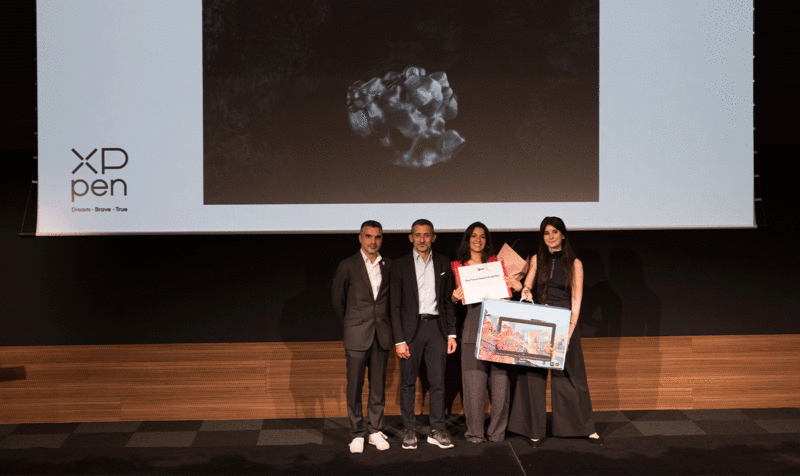 Dirección y staff académico del IED Barcelona entregando en el escenario una tableta a la estudiante ganadora del Best Thesis de Visual Arts del IED Barcelona