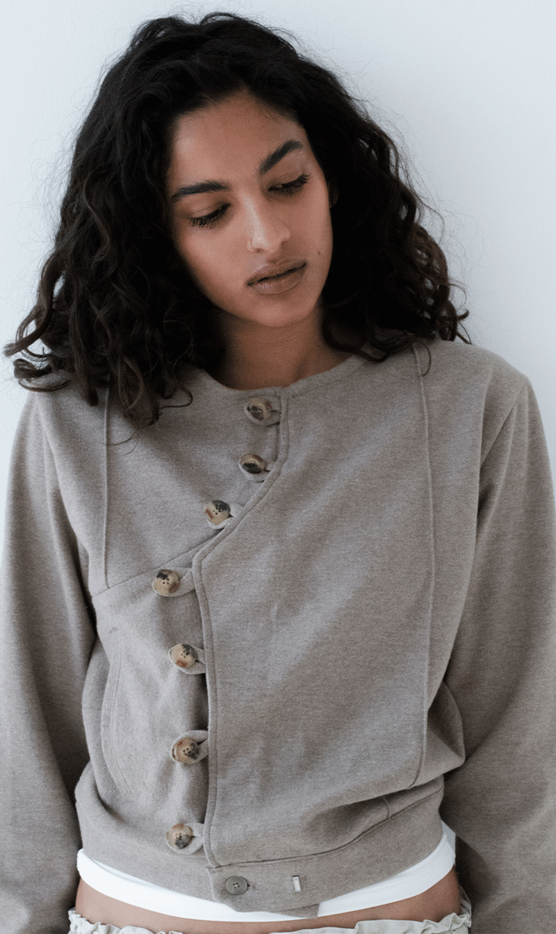 Una modelo vistiendo una chaqueta en colores neutros y diseño limpio inspirada en la filosofía japonesa del Wabi Sabi