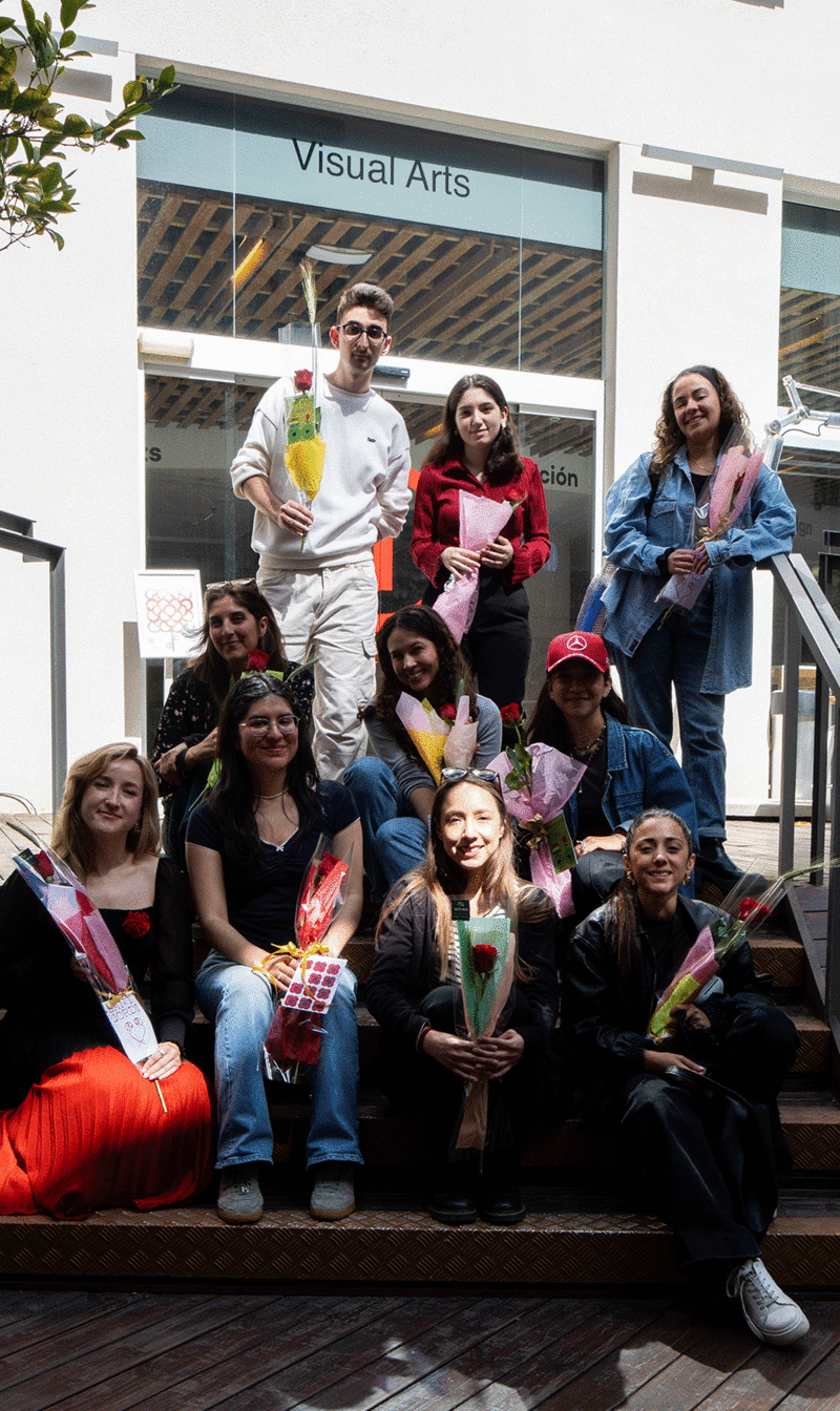 Un grupo de estudiantes posa sentado en las escaleras del patio del IED Barcelona con las rosas de Sant Jordi listas para entregar a tres residencias del barrio de Gràcia 