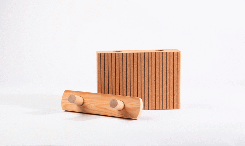 Un panel encajable de corcho junto al sistema de fijación de madera en fondo blanco