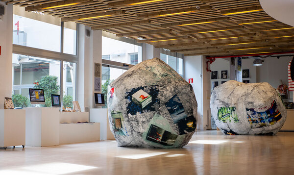 Exposición de arte y diseño que muestra dos rocas centrales cosidas con telas estampadas
