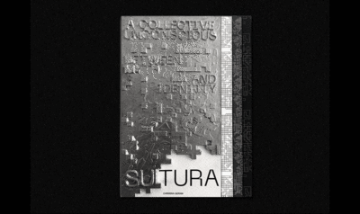 Un libro de metal con letras en relieve sobre un fondo negro