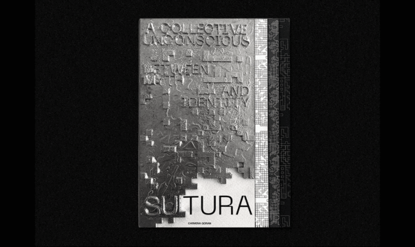 Un libro de metal con letras en relieve sobre un fondo negro