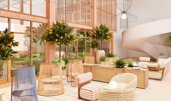 Interior de un espacio urbano con sofás de materiales naturales y paredes de cristal que dan a un jardín interior y una escalinata ovalada al fondo en tonos blancos