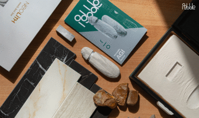 Plano detalle de una mesa de despacho con documentos dispuestos de manera ordenada en diagonal y un dispositivo AIG blanco con forma de punta de sílex y textura de piedra en el centro